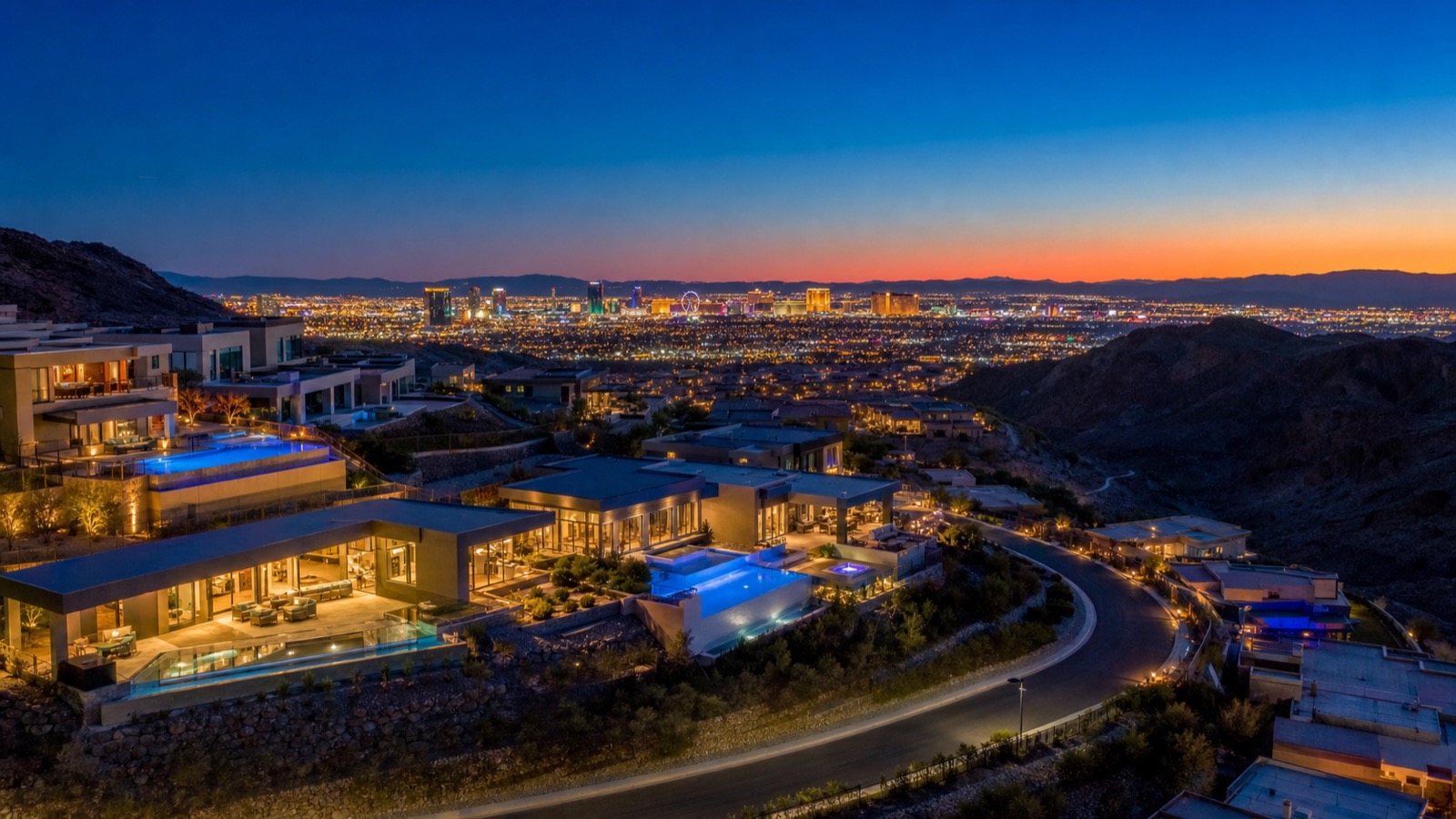 Henderson hillside guard-gated community at twilight with Las Vegas Strip view in the distance